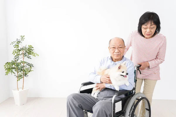 old woman caring for her husband in the wheelchair