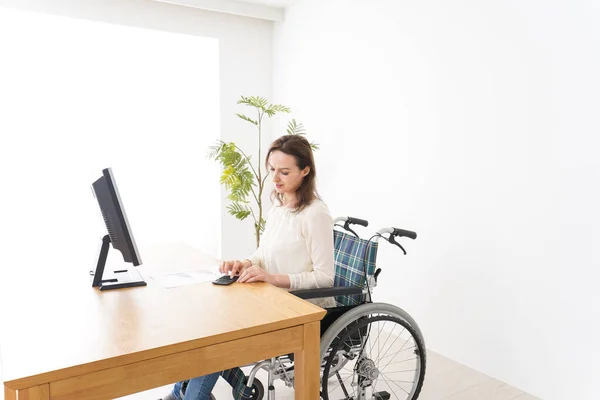 Młoda Kobieta Pracuje Biurkiem Wózku Inwalidzkim — Zdjęcie stockowe