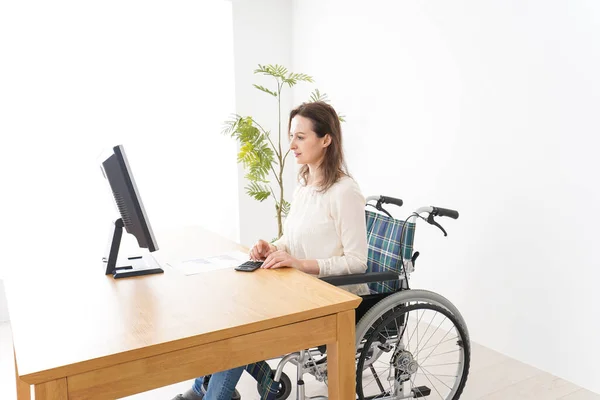 Młoda Kobieta Pracuje Biurkiem Wózku Inwalidzkim — Zdjęcie stockowe