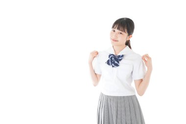 Gülümseyen kız öğrenci üniforması giyiyor.