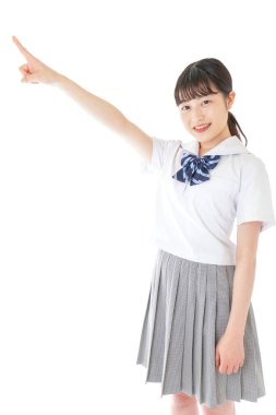 gülümseyen genç Asyalı kız öğrenci bir şeyi işaret ediyor 