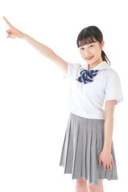 gülümseyen genç Asyalı kız öğrenci bir şeyi işaret ediyor 