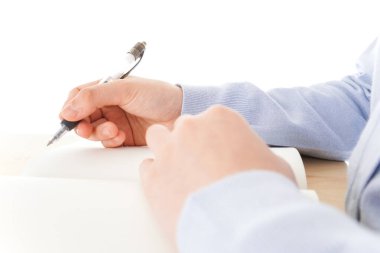 Genç Asyalı kız öğrenci masada oturuyor. 