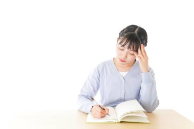 Masada düşünen genç Asyalı kız öğrenci.