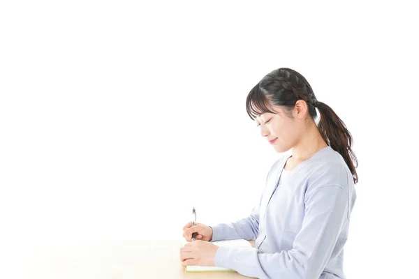 机に座って勉強する若い女性アジア人学生 — ストック写真