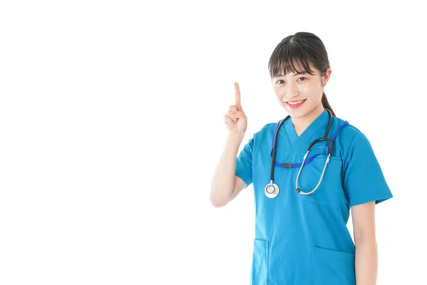 Een Jonge Verpleegster Met Een Glimlach Die Iets Wijst — Stockfoto