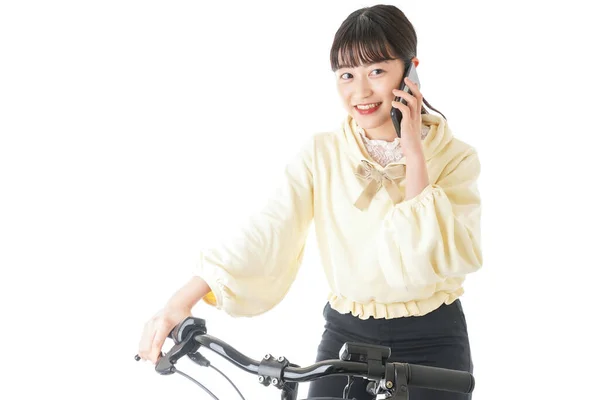 スマートフォンを使って自転車に乗る若い女性 — ストック写真