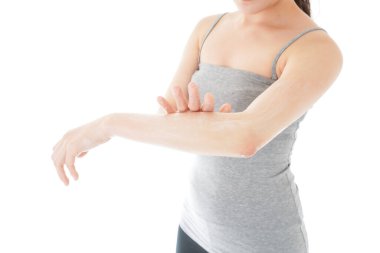 Güneş kremi kullanan genç bir kadın.