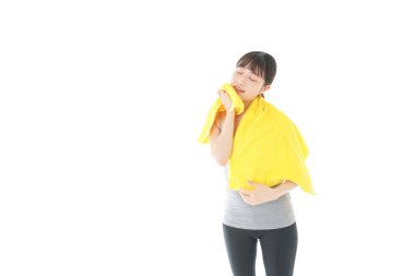 Sarı havlusu olan genç bir kadın beyazın üzerinde izole edilmiş.