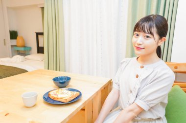 Genç bir kadın kahvaltısını yapacak.  