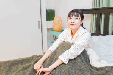 Genç kadın yatakta dinleniyor.