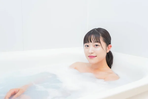用泡沫洗澡的年轻妇女 — 图库照片