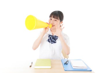 Üniformalı genç öğrenci abur cubur yiyor ve çalışıyor.