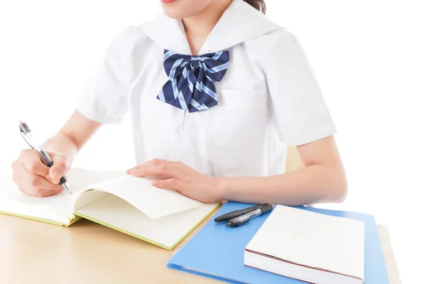 穿着制服在课桌学习的年轻女生 — 图库照片