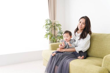 Anne bebeği kanepede oturuyor ve evde dinleniyor.