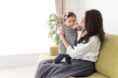 Anne bebeği kanepede oturuyor ve evde dinleniyor.