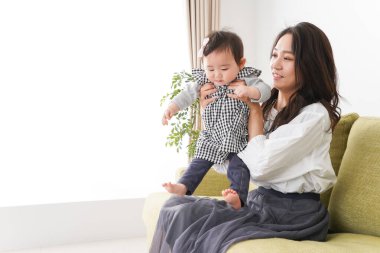 Anne bebeği kanepede oturuyor ve evde dinleniyor.