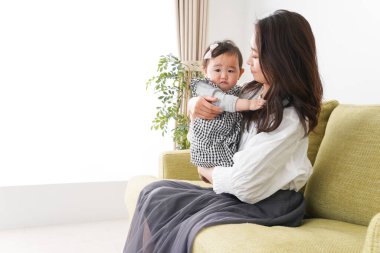 Anne bebeği kanepede oturuyor ve evde dinleniyor.