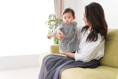 Anne bebeği kanepede oturuyor ve evde dinleniyor.