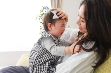 Anne bebeği kanepede oturuyor ve evde dinleniyor.