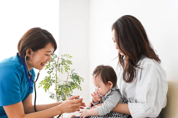 Mom with her baby receive an examination at the hospital, Doctor examining a baby