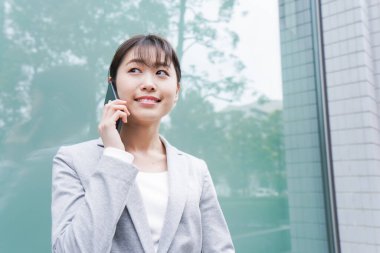 Ofis bölgesinde telefonu olan genç bir iş kadını.