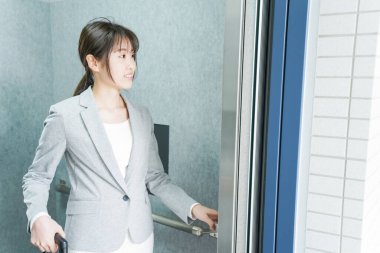 Asansörü kullanan genç iş kadını, asansördeki genç iş kadını. 