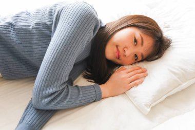 Yatakta genç Asyalı kadın