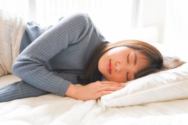 Yatakta genç Asyalı kadın