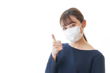 Bir şey gösteren maskeli genç bir kadın.