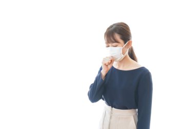 Maske takan genç bir kadın öksürük belirtileri gösteriyor.