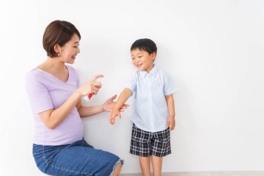  Anne çocuğunun ellerini sterilize etmek için sprey kullanıyor.