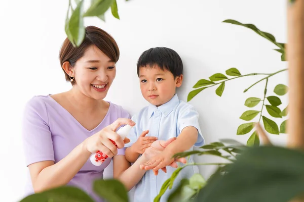 Mãe Usando Spray Para Higienizar Mãos Seu Filho — Fotografia de Stock