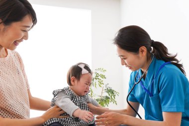 Genç doktor bebeği muayene ediyor.