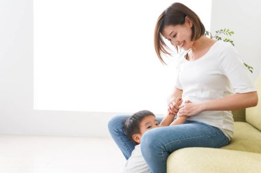 Çocuklar ve anne evde oynuyorlar.