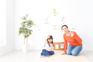 Anadil öğretmeniyle İngilizce okuyan küçük çocuk.