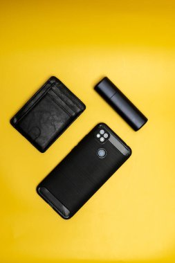 Akıllı telefon deri cüzdanı ve sarı arka planda elektronik sigara.