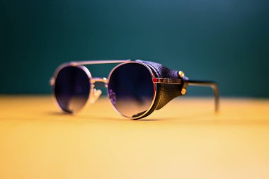 Koyu arkaplanda deri parçaları olan steampunk güneş gözlüğü.