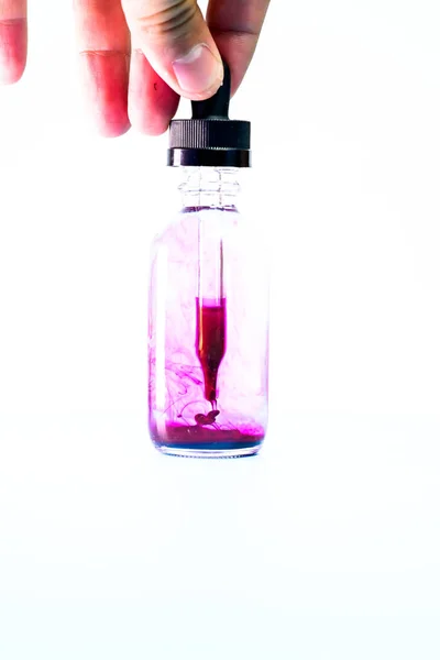 Frasco de vidro com tinta roxa sobre fundo branco — Fotografia de Stock