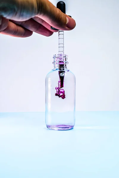 Kolba szklana z fioletową farbą na białym tle — Zdjęcie stockowe