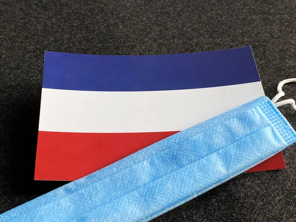 네덜란드 국기는 어두운 배경의 마스크 근처에 관광객들의 선수권 — 스톡 사진