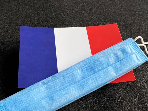 프랑스 국기는 어두운 배경의 마스크 근처에 관광객들의 선수권 — 스톡 사진