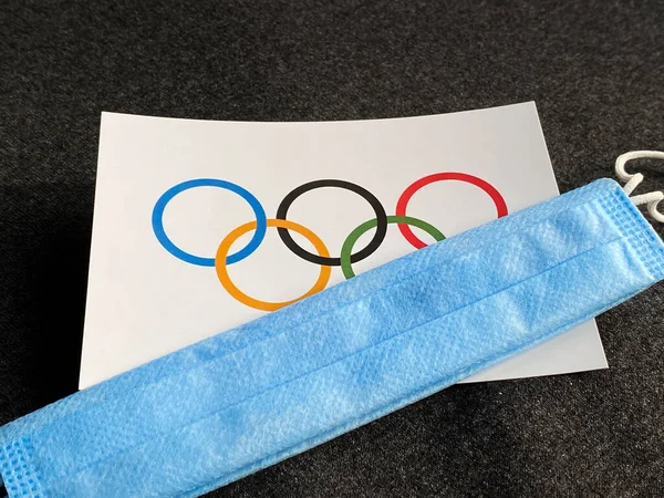 ロシアのマリ 2021年6月12日 オリンピックの旗とリングは 濃い灰色の背景の青いマスクの近くにあります 観光旅行 ヨーロッパ世界選手権 ストックフォト