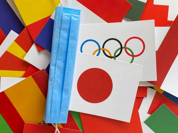 ロシアのマリ エル2021年6月12日 オリンピックと日本の国旗が医療用青いマスクの隣に世界中に掲揚されています 東京2020大会出場 観光旅行 選手権 ストック写真
