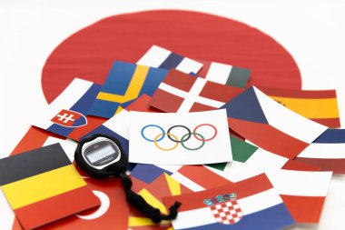 Mari El, Rusya - 16 Haziran 2021: Halkalı Olimpiyat bayrağı, kronometre dünyanın bayraklarında. Japon bayrağı arka planı. Şampiyonluk