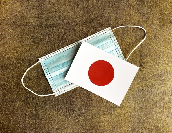 Bandeira Japonesa Uma Máscara Facial Estão Fundo Dourado Tóquio — Fotografia de Stock