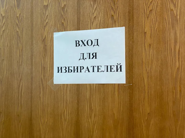 Марий Эл, Россия - 16 сентября 2021 года: На деревянной двери или стене висит лист белой бумаги с надписью на русском языке - Вход для избирателей. Выборы в Государственную Думу 19 сентября 2021 года — стоковое фото