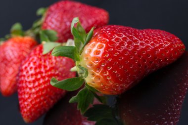 siyah bir zemin üzerine kırmızı çilek. Berry parlak kontrast görüntü.