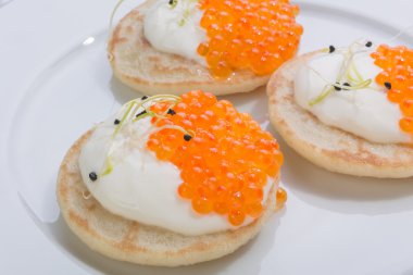 Krep krema ile üzerinde kırmızı balık havyar. Beyaz tabakta yemek. metin için yer.