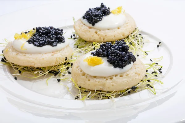 Krep krema ve pırasa lahanası bir yatak üzerinde kızarmış balık havyar. Beyaz tabakta yemek. metin için yer.